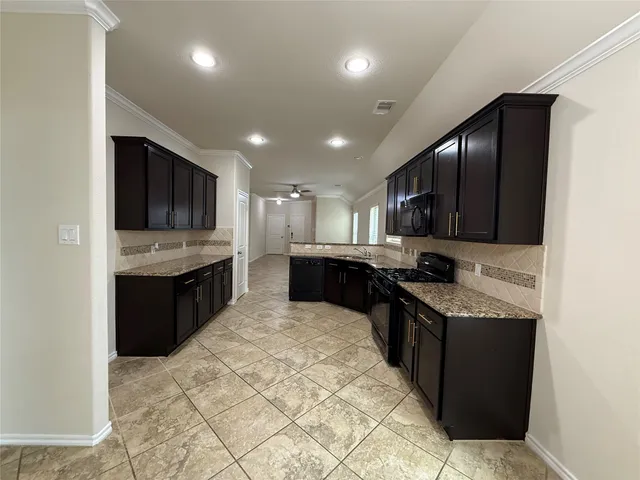 a kitchen with stainless steel appliances granite countertop a stove a sink and a microwave
