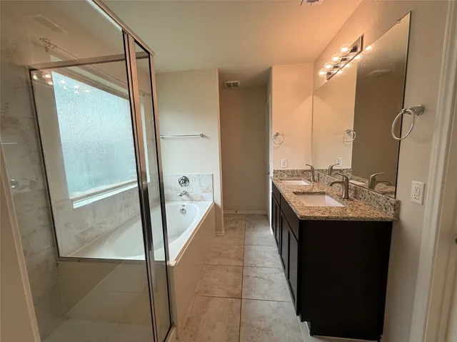a bathroom with a granite countertop sink a mirror and a bathtub