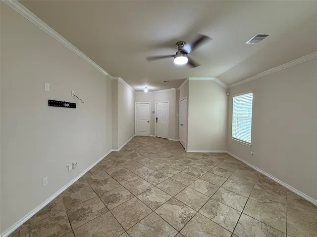 a view of an empty room with a kitchen and a window