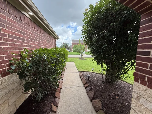 a view of a pathway with a flower garden