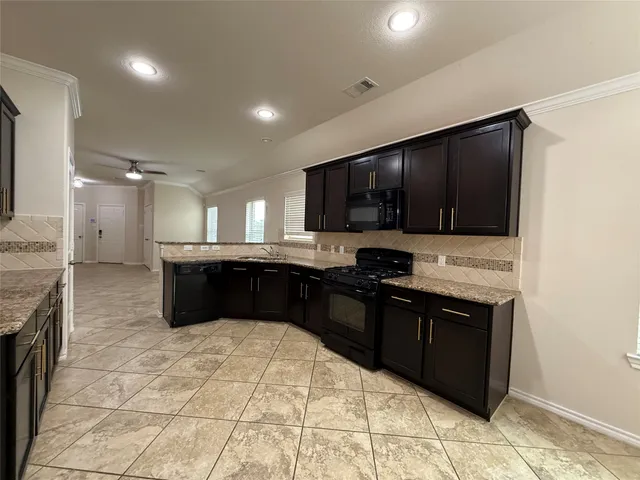 a kitchen with a sink and a stove top oven with wooden cabinets