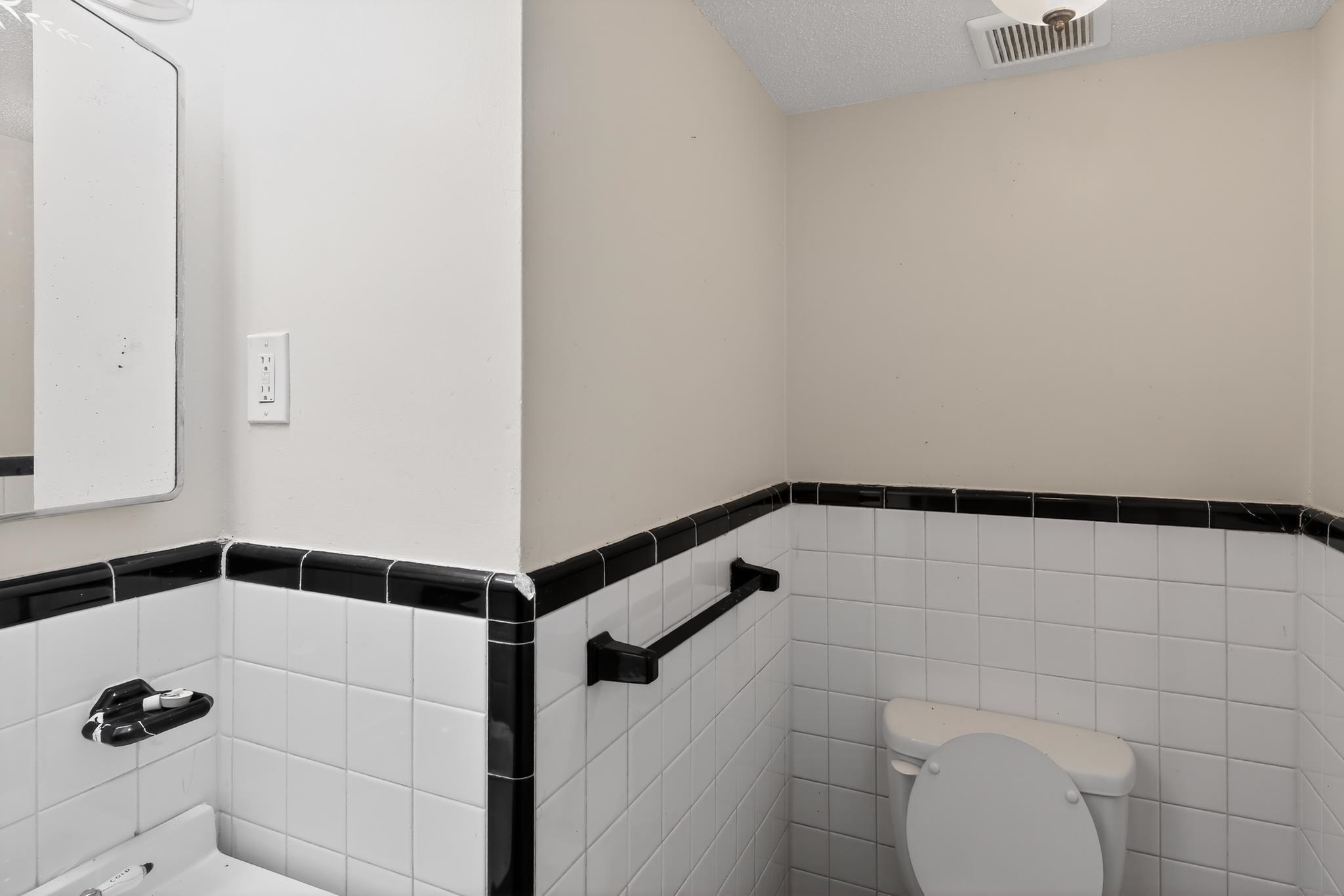 1403 Old Hickory Road Memphis, TN 38116 - Photo 23 of 31 Bathroom featuring white subway tile with black trim, a recessed ceiling light, and a wall-mounted mirror