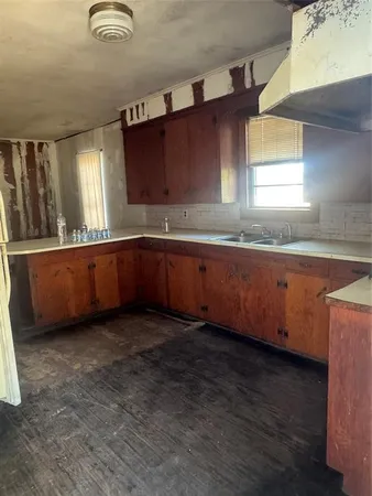 a kitchen with granite countertop a sink and cabinets