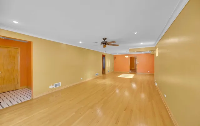 a view of a big room with wooden floor and windows