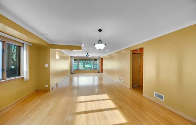 a view of a hallway with wooden floor and a living room