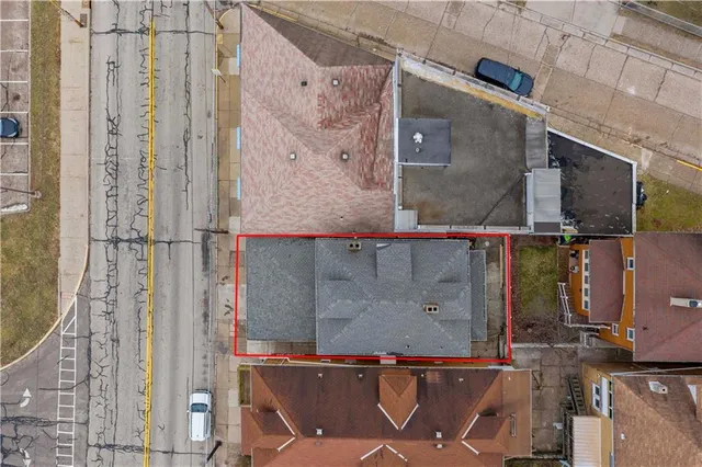 an aerial view of residential houses with outdoor space and parking