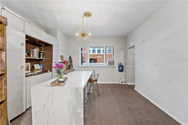 a dining room with furniture and a kitchen space