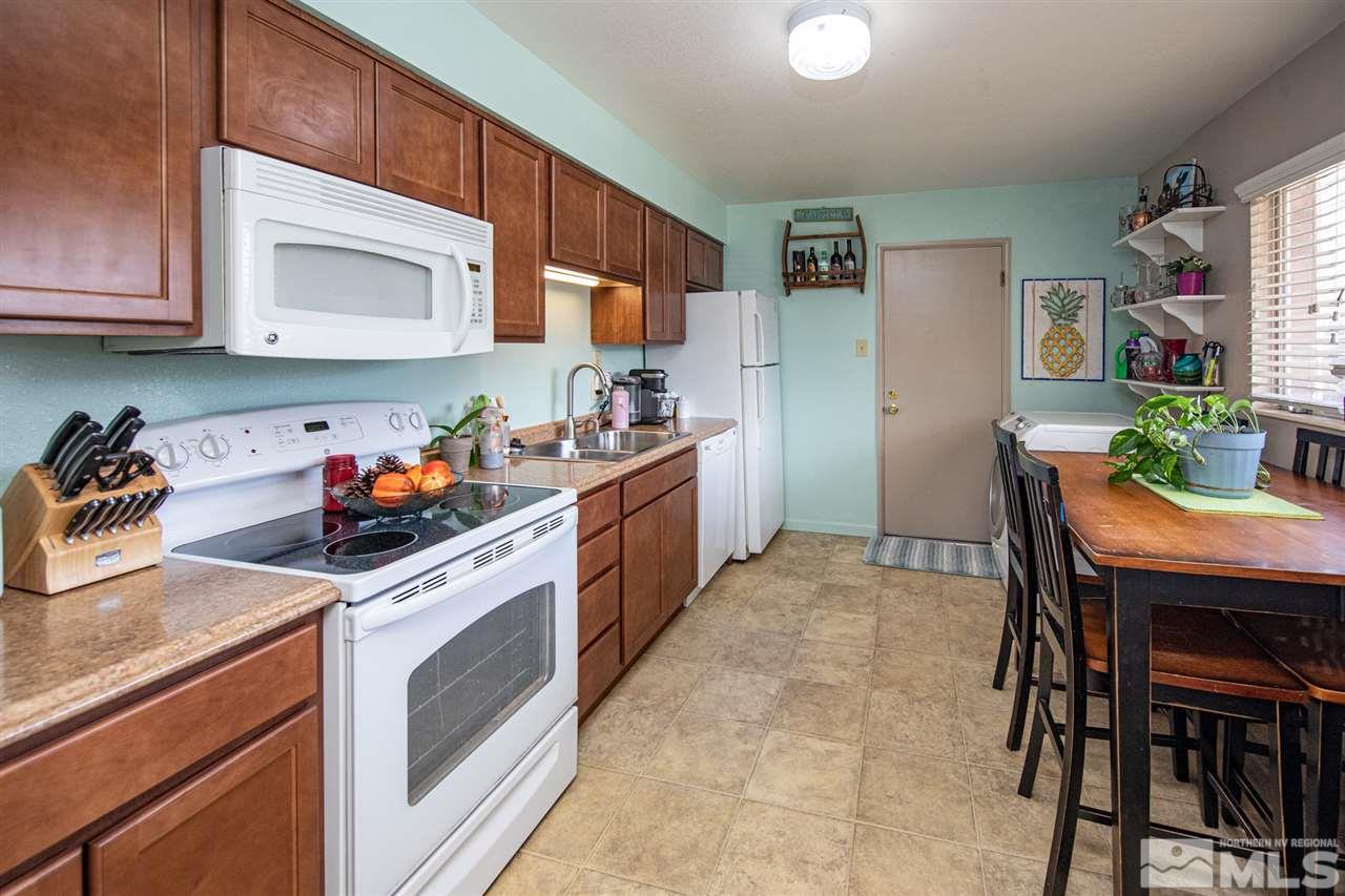 415 West Arroyo Street Reno, NV 89509 - Photo 4 of 33 a kitchen with stainless steel appliances granite countertop a table chairs cabinets and a sink
