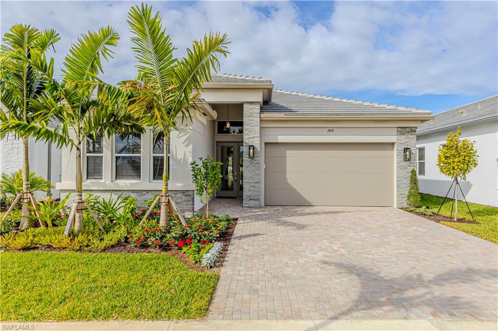 2691 Ridgecrest Place Naples, FL 34112 - Photo 1 of 27 a front view of a house with a yard and a garage