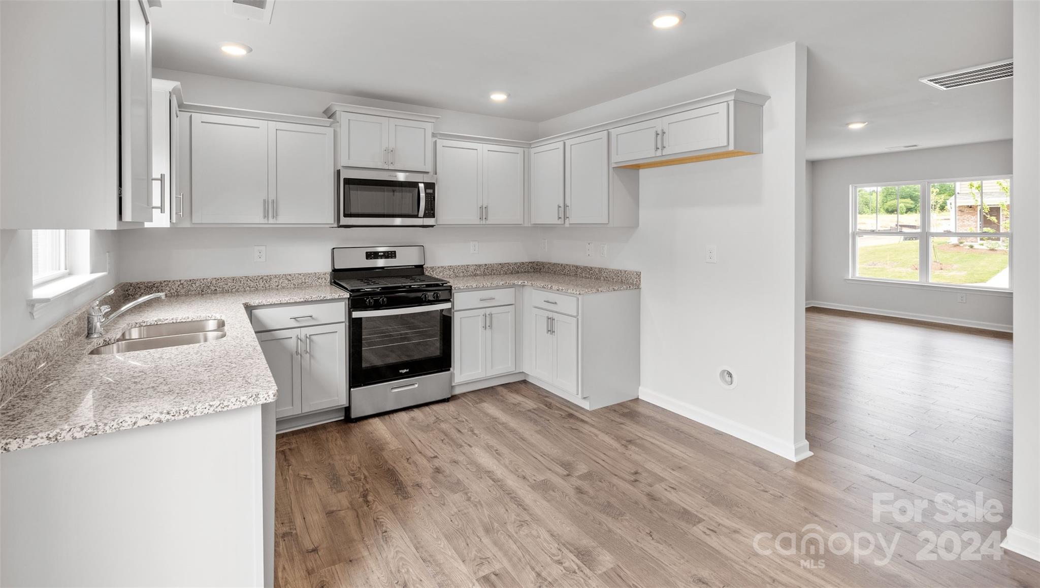 61 Callie River Clyde, NC 28721 - Photo 6 of 23 a kitchen with granite countertop white cabinets and white appliances