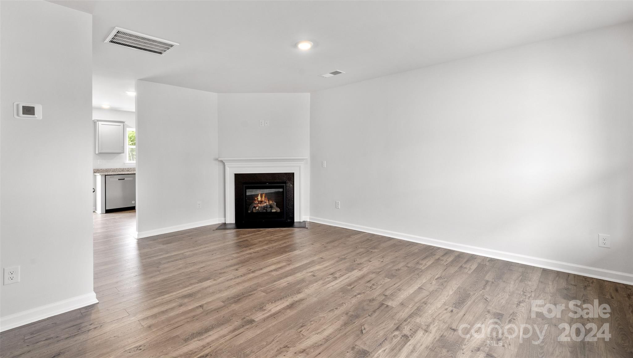 61 Callie River Clyde, NC 28721 - Photo 10 of 23 a view of an empty room with wooden floor and a fireplace