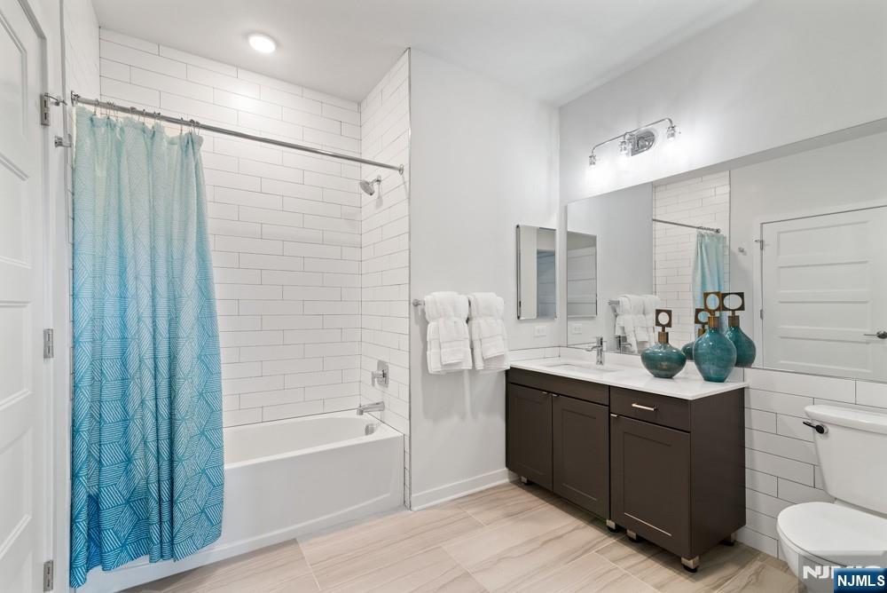 15 West Johnson Avenue, Unit 304 Bergenfield, NJ 07621 - Photo 13 of 15 a bathroom with a double vanity sink a toilet and shower