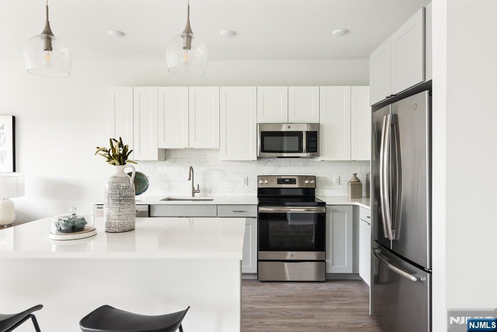 15 West Johnson Avenue, Unit 304 Bergenfield, NJ 07621 - Photo 8 of 15 a kitchen with a sink stainless steel appliances and white cabinets