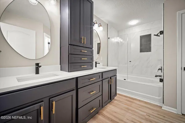 a spacious bathroom with a double vanity sink a mirror and a bathtub
