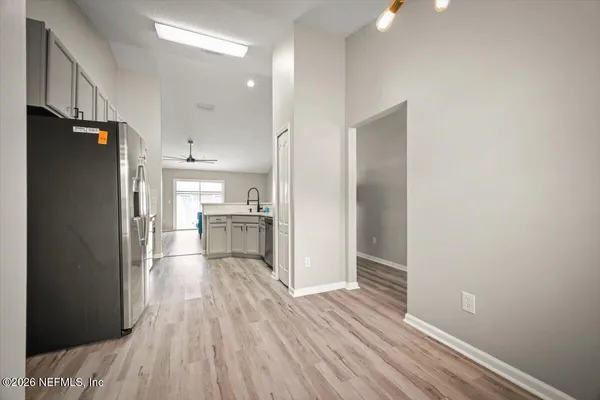 a view of a kitchen with wooden floor a sink and a refrigerator