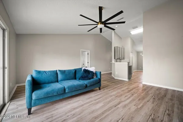 a living room with furniture and a wooden floor