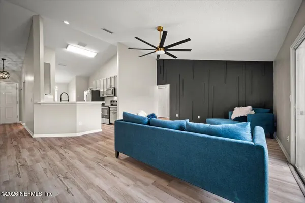 a living room with furniture and kitchen view
