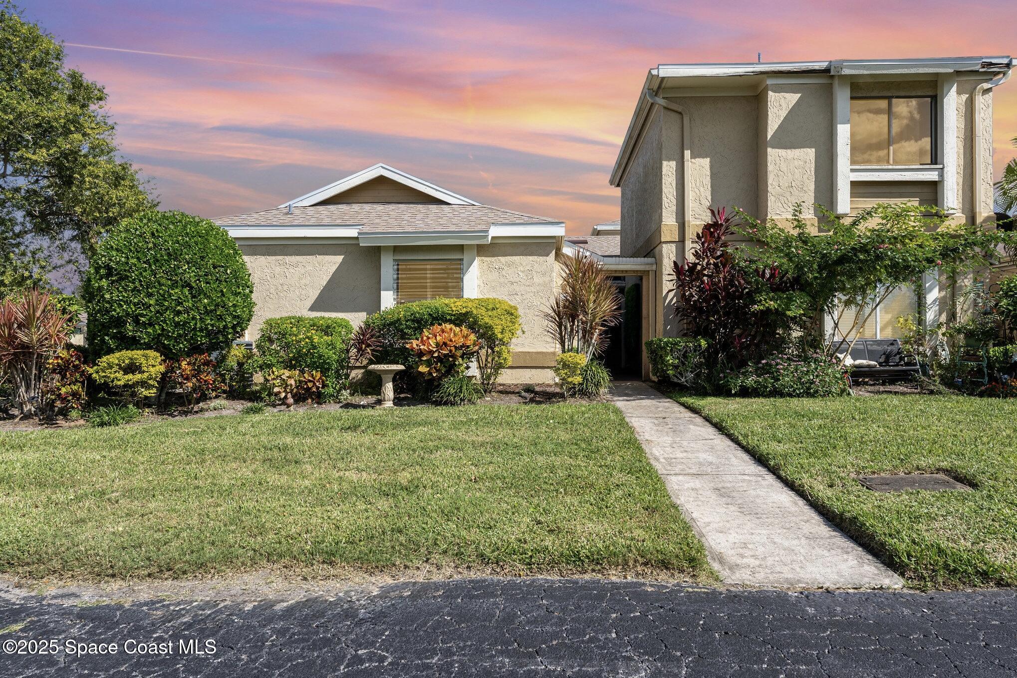1411 Sheafe Avenue Northeast, Unit 101 Palm Bay, FL 32905 - Photo 1 of 25 a front view of a house with a yard