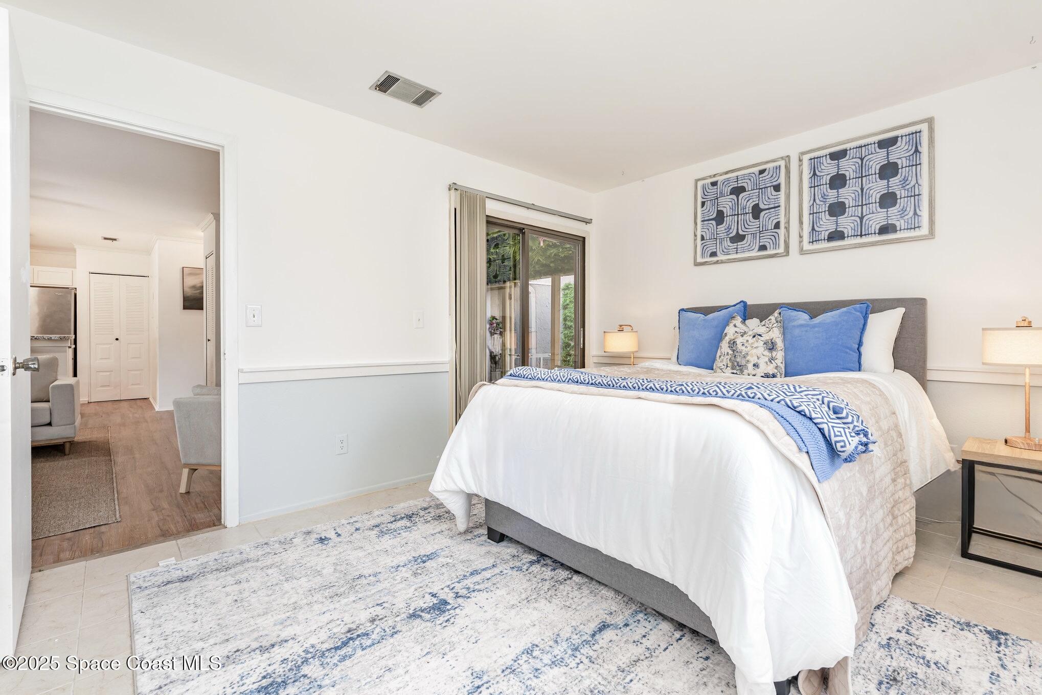 1411 Sheafe Avenue Northeast, Unit 101 Palm Bay, FL 32905 - Photo 11 of 25 a bedroom with a large bed and a chandelier