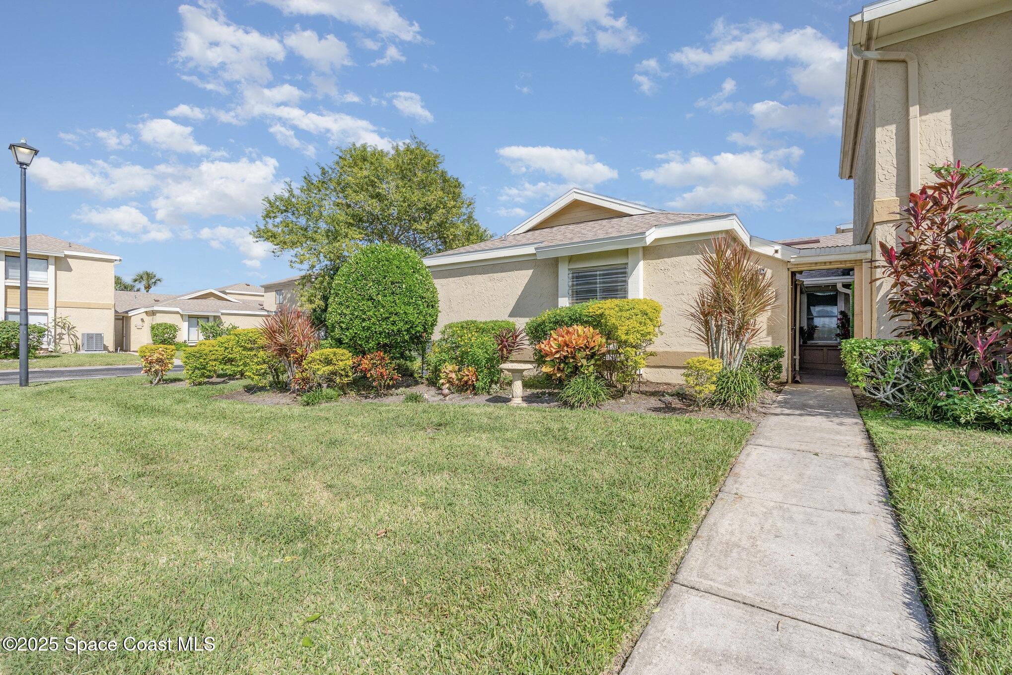 1411 Sheafe Avenue Northeast, Unit 101 Palm Bay, FL 32905 - Photo 3 of 25 a front view of a house with garden
