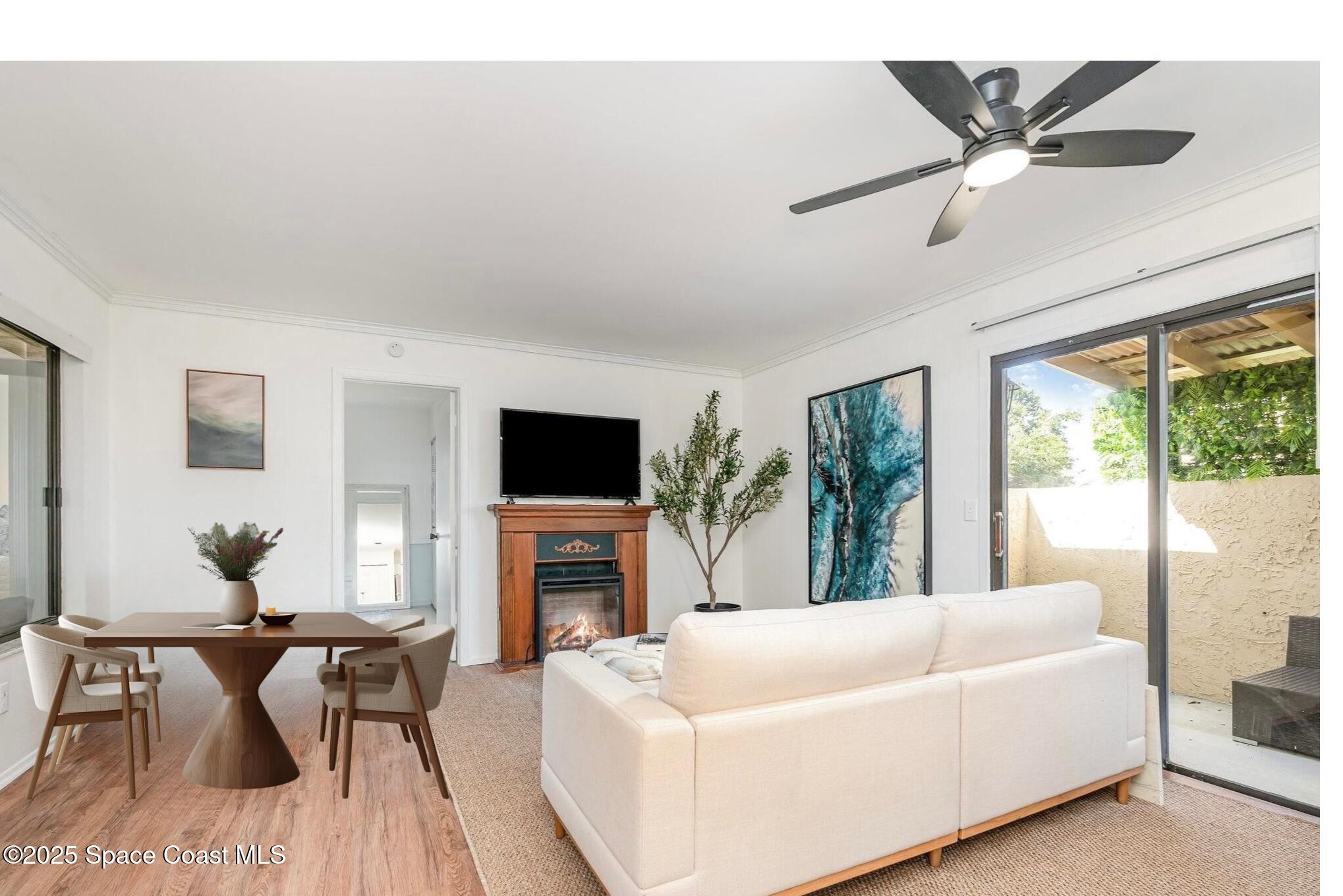 1411 Sheafe Avenue Northeast, Unit 101 Palm Bay, FL 32905 - Photo 4 of 25 a living room with furniture a fireplace and a flat screen tv