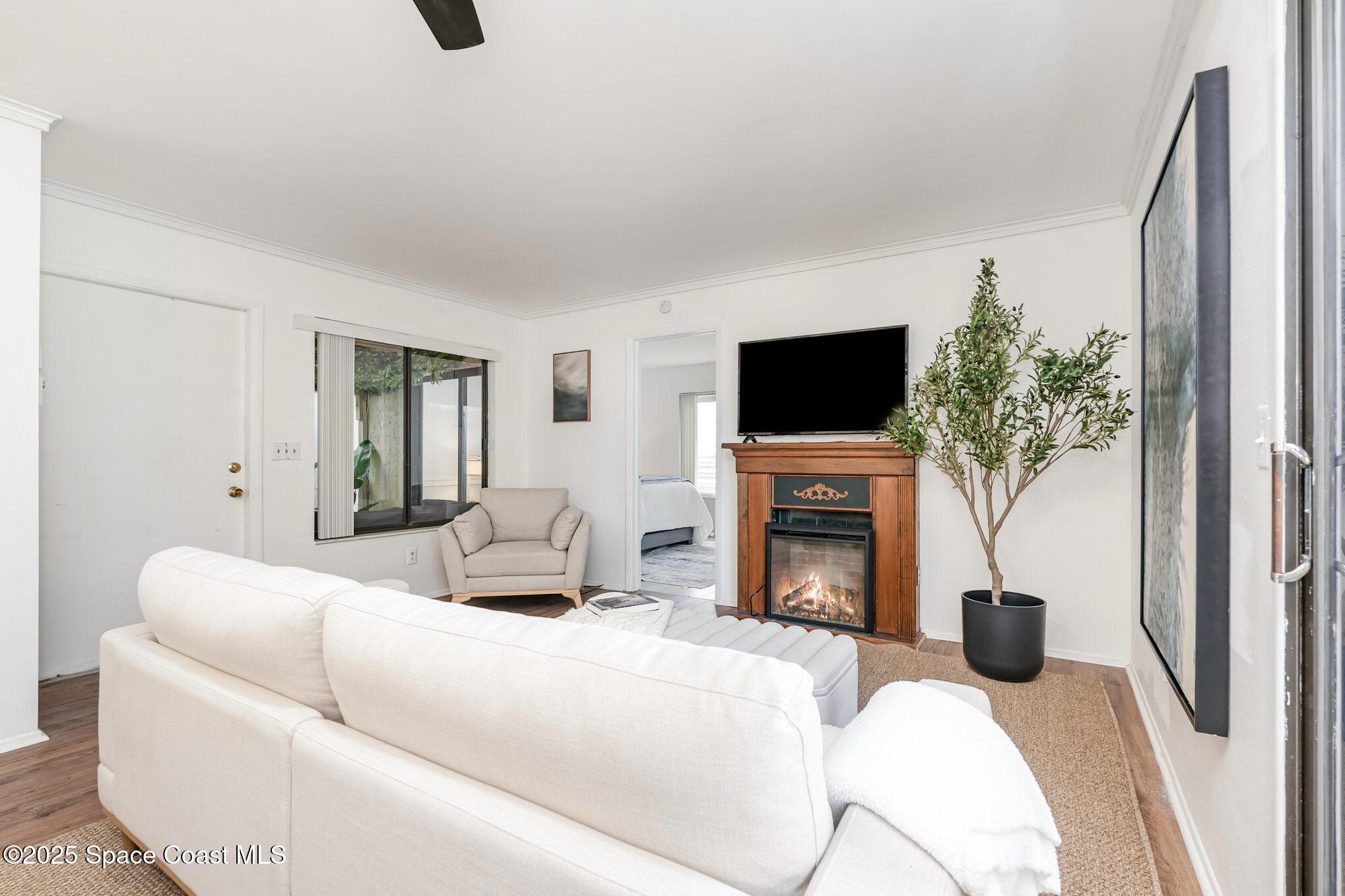 1411 Sheafe Avenue Northeast, Unit 101 Palm Bay, FL 32905 - Photo 5 of 25 a living room with fireplace furniture and a flat screen tv