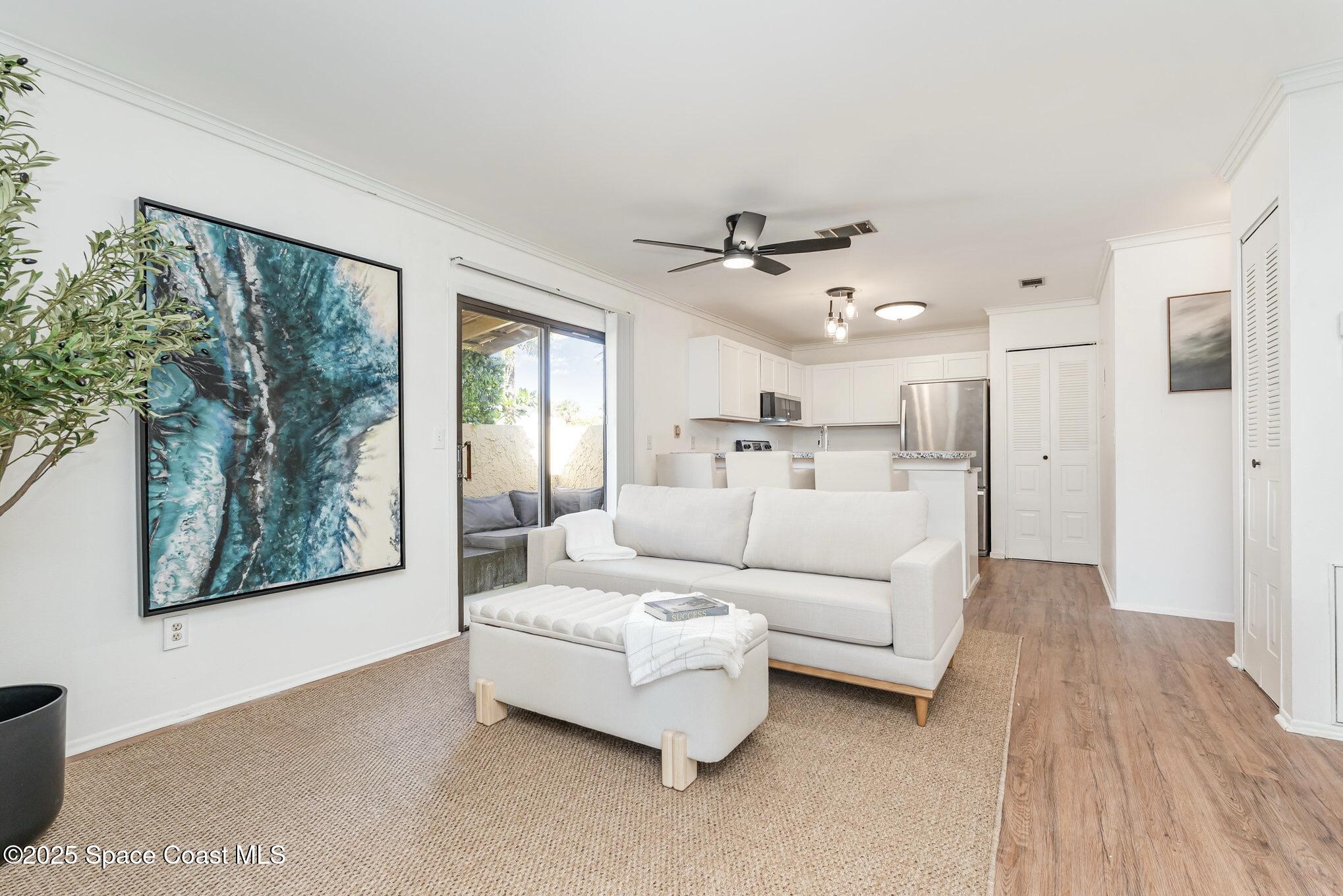 1411 Sheafe Avenue Northeast, Unit 101 Palm Bay, FL 32905 - Photo 6 of 25 a living room with furniture and a large window