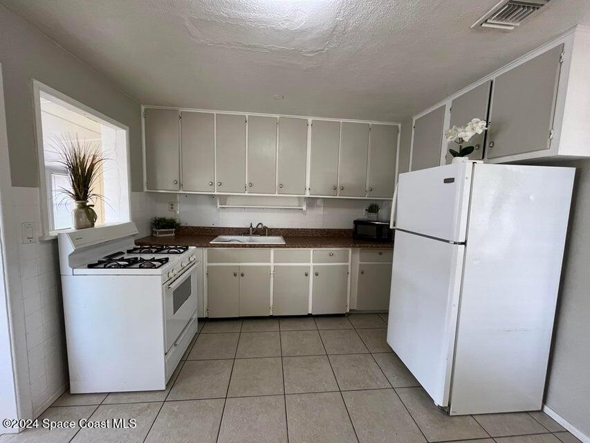 58 Shady Lane Rockledge, FL 32955 - Photo 5 of 12 a kitchen with a refrigerator sink stove and cabinets