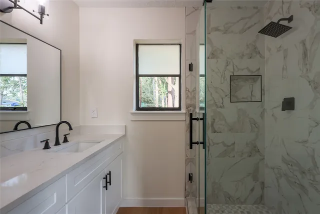a bathroom with a shower sink and mirror