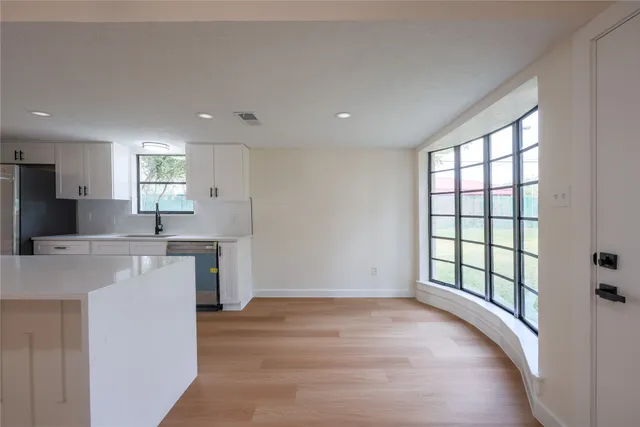 a view of a kitchen with a sink and dishwasher a oven with wooden floor