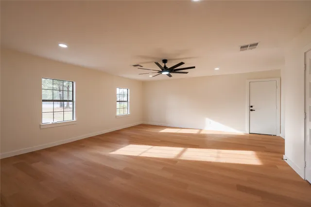 a view of a big room with wooden floor and windows in a room