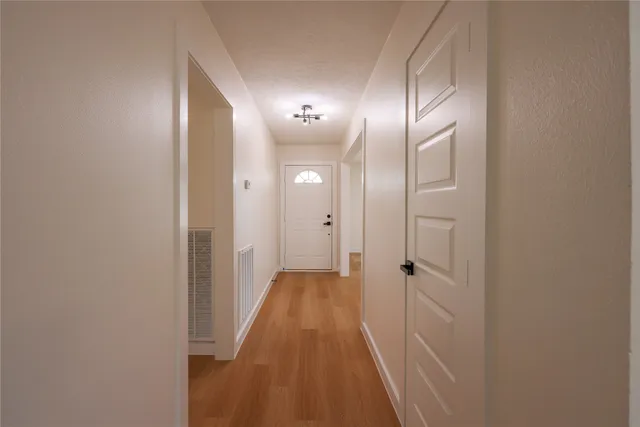 a view of a hallway with wooden floor