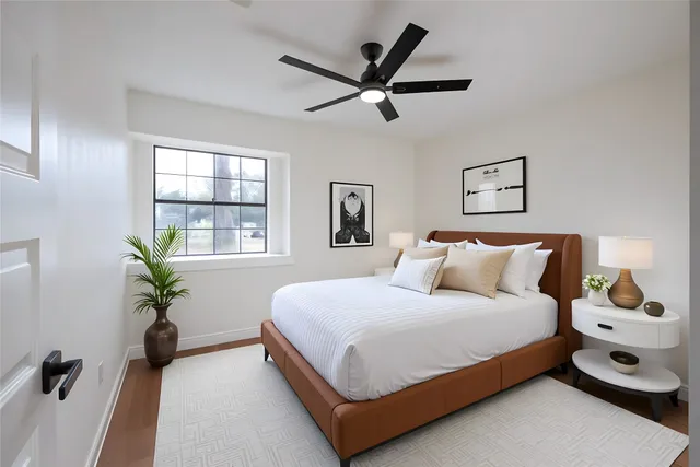 a bedroom with a bed a dresser and a chandelier