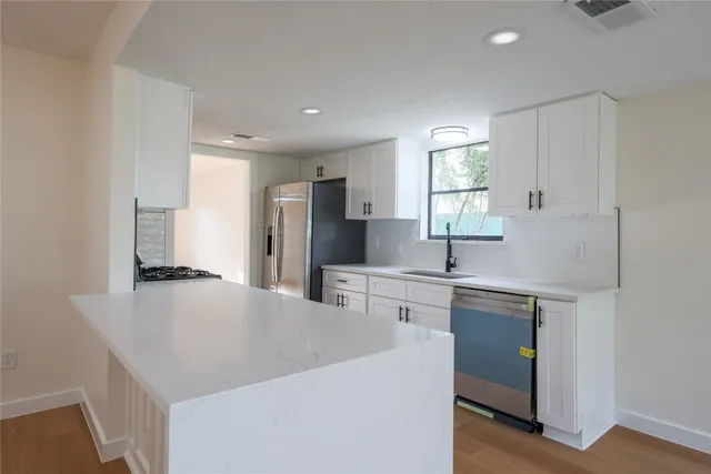 a kitchen with stainless steel appliances a sink stove and refrigerator