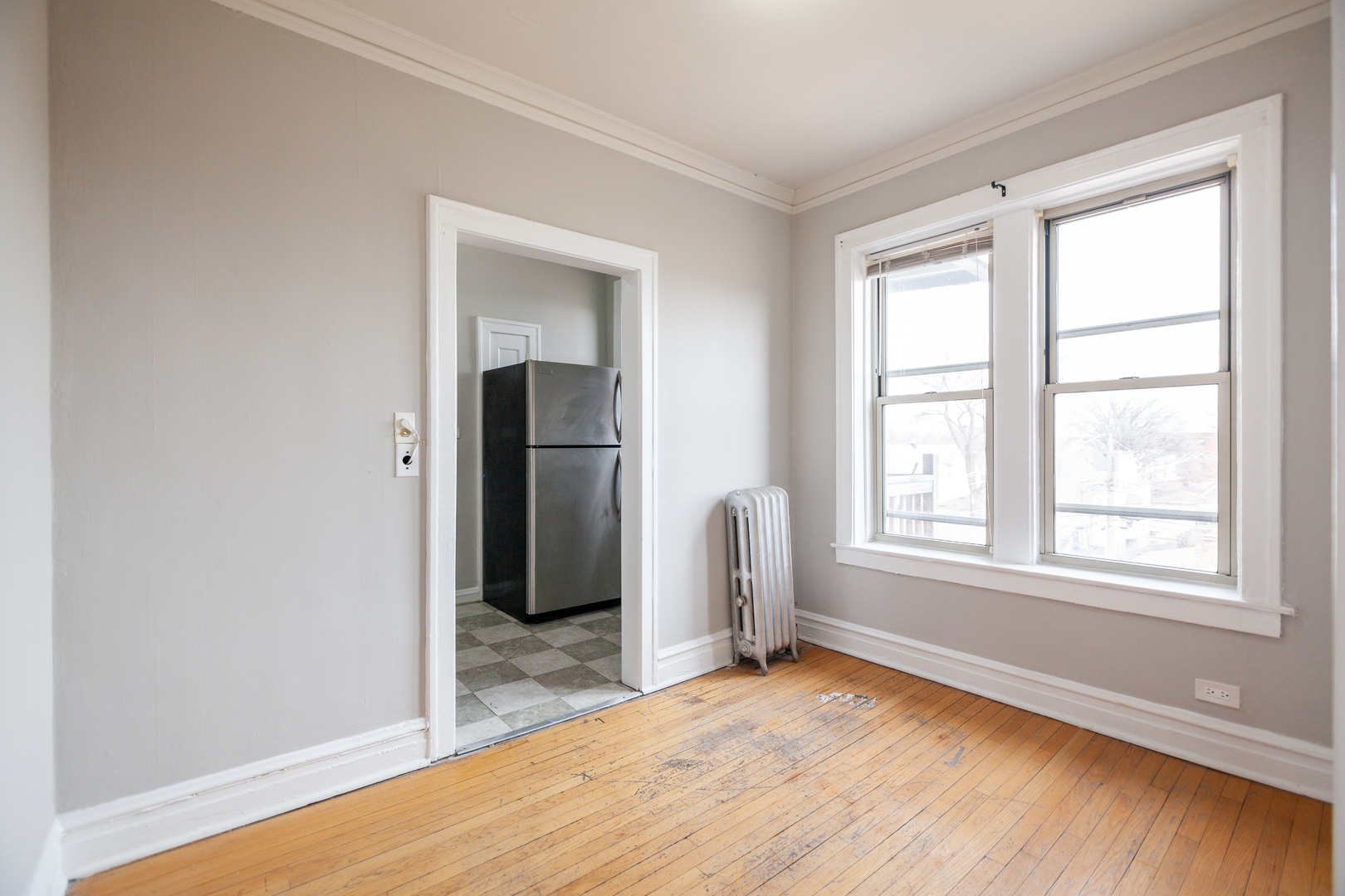 3537 North Troy Street, Unit 3 Chicago, IL 60618 - Photo 3 of 6 an empty room with wooden floor and windows