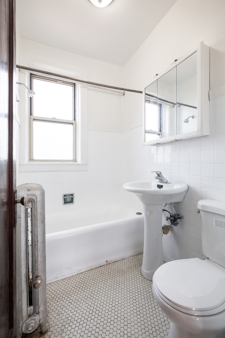 3537 North Troy Street, Unit 3 Chicago, IL 60618 - Photo 6 of 6 a white toilet sitting next to a bathroom sink