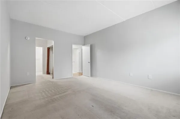 a view of an empty room with closet and a window