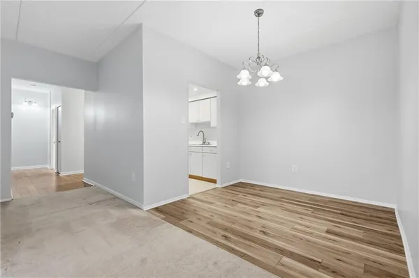 a view of an empty room with chandelier fan
