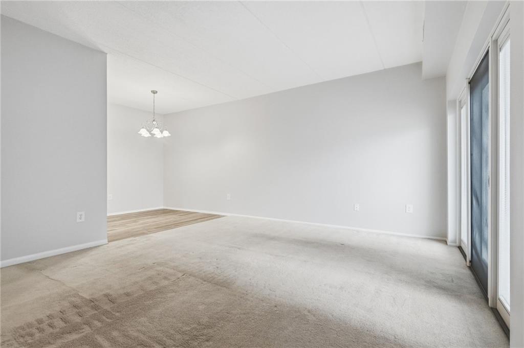 5600 Munhall Road, Unit 202 Pittsburgh, PA 15217 - Photo 9 of 24 an empty room with a chandelier fan and windows