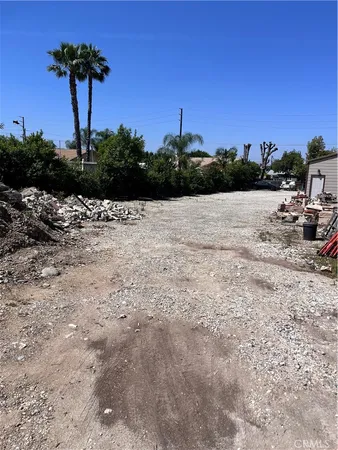a view of a dry yard with wooden fence