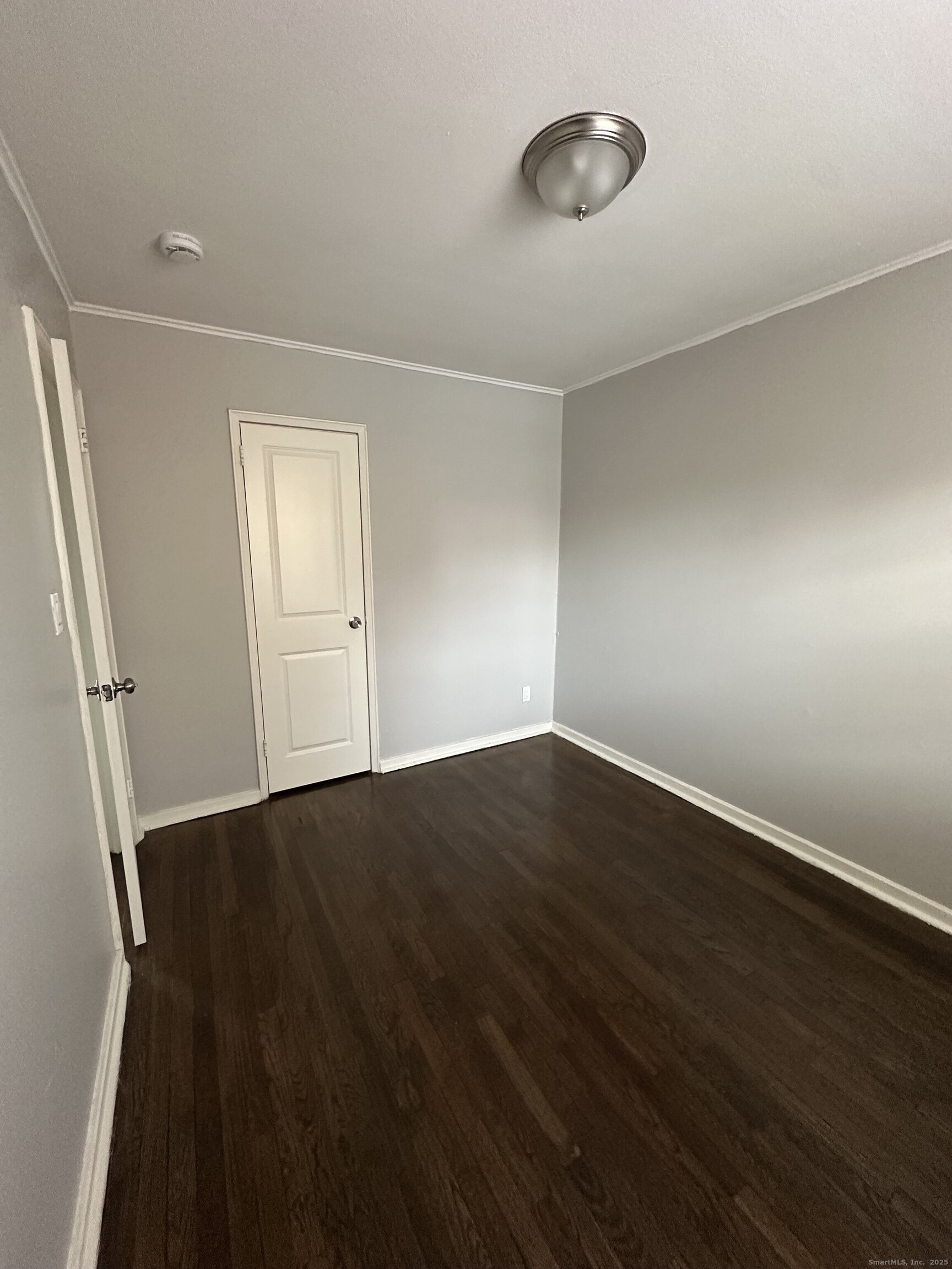 14 Hillcrest Avenue, Unit 14B West Hartford, CT 06110 - Photo 5 of 8 an empty room with wooden floor and windows