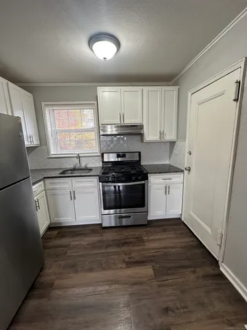 a kitchen with stainless steel appliances a stove a sink and a refrigerator
