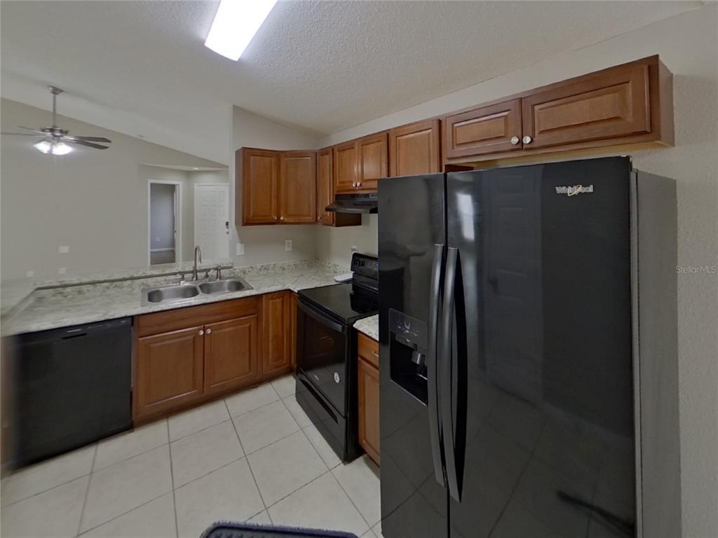 Undisclosed Address Riverview, FL 33578 - Photo 5 of 15 a kitchen with granite countertop cabinets and refrigerator