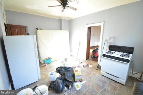 a kitchen with stainless steel appliances a stove a refrigerator white cabinets a dining table and chairs