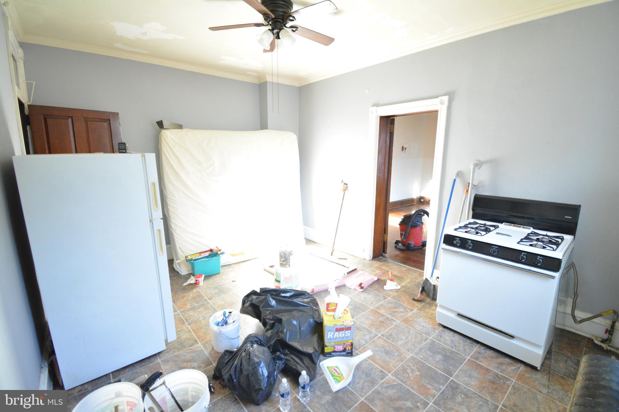 102 Manheim Street, Unit 2 Philadelphia, PA 19144 - Photo 10 of 13 a kitchen with stainless steel appliances a stove a refrigerator white cabinets a dining table and chairs