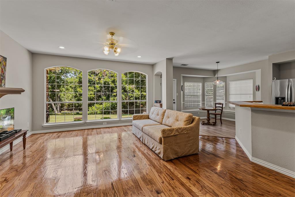 9301 Nottingham Court Rowlett, TX 75088 - Photo 5 of 39 Living area featuring wood-finish flooring and three arched windows with exterior views