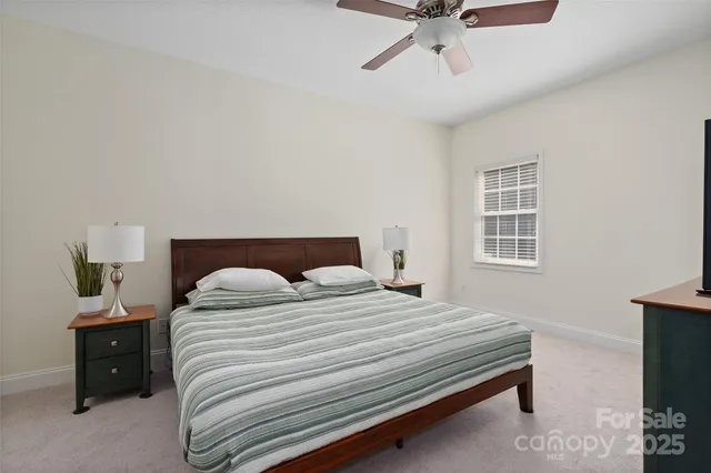 a bedroom with a bed and a lamp on the dresser