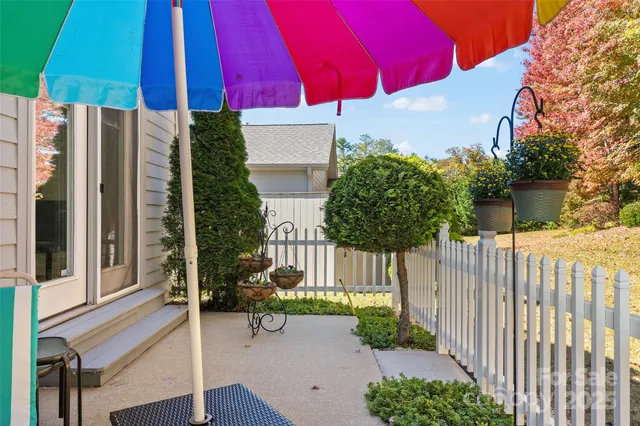 a view of a patio with a table and chairs under an umbrella