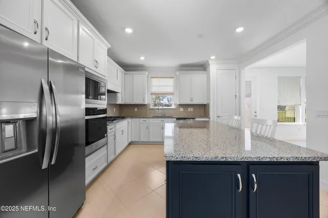 a kitchen with kitchen island granite countertop a sink stove and refrigerator