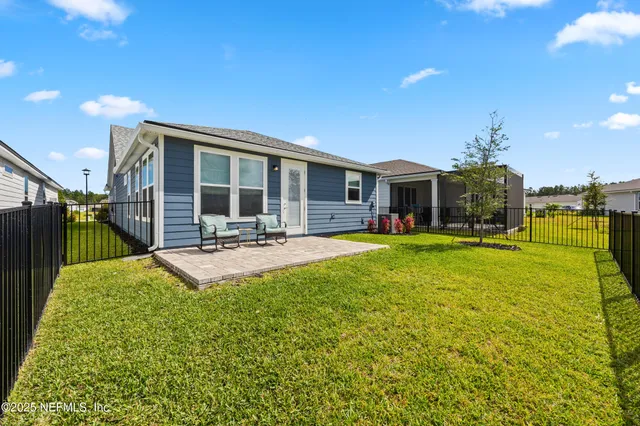 an aerial view of a house with a yard and swimming pool